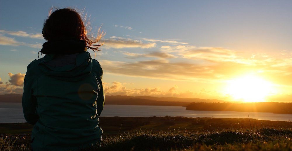 A person looking at a sunset.