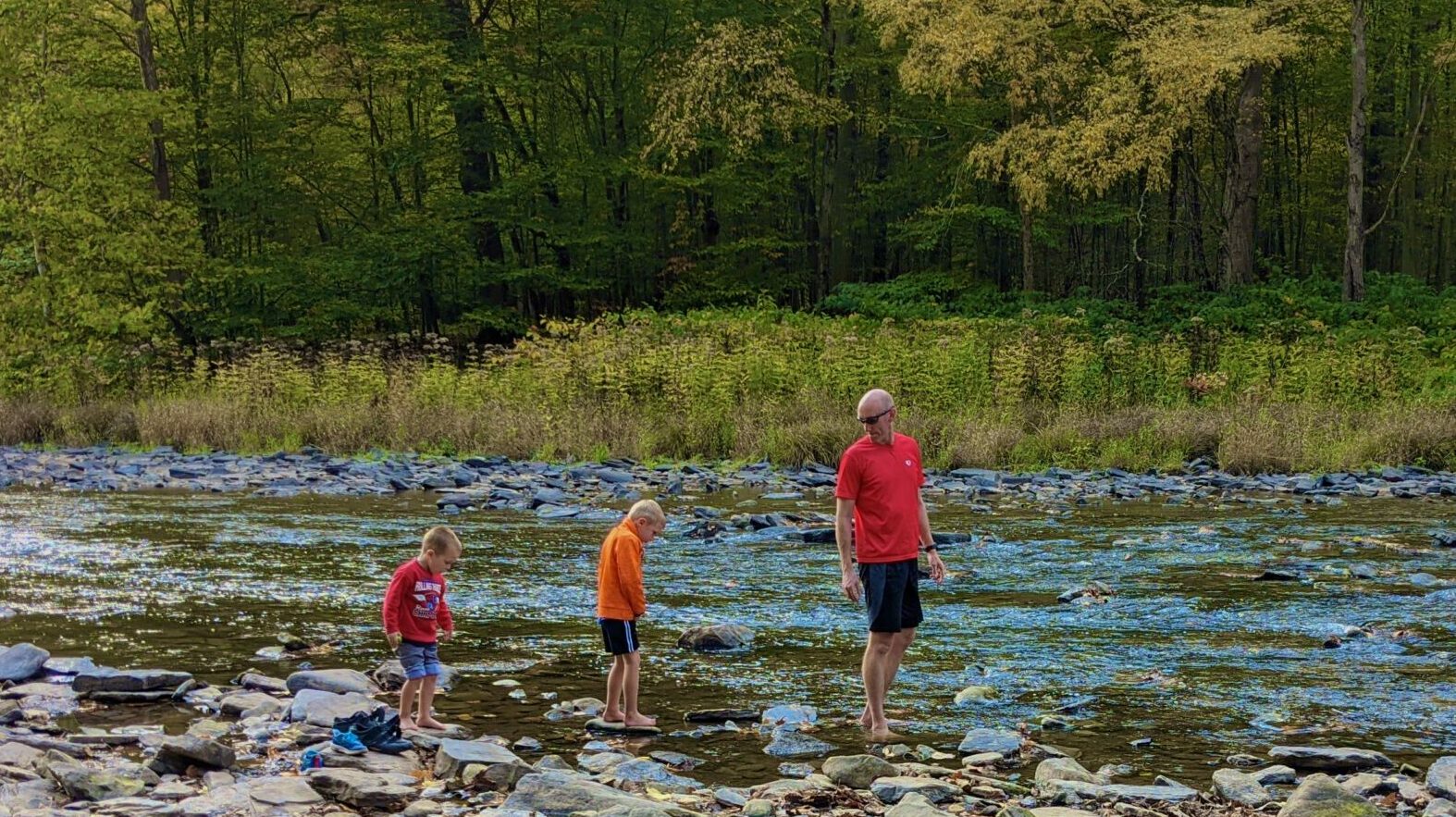 People playing in a shallow river.